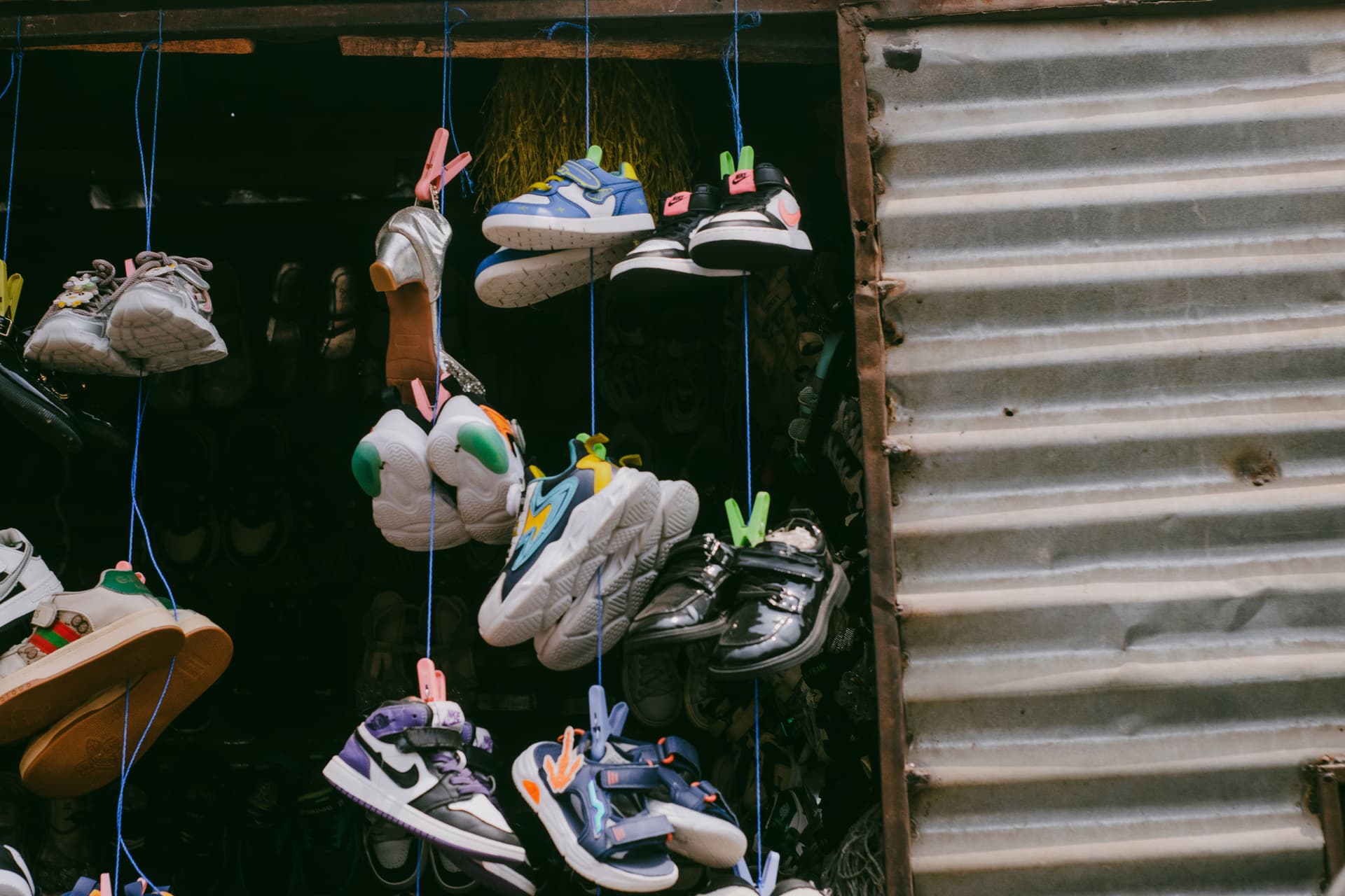 Colorful sneakers hanging for sale in an outdoor street market.